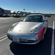 A silver 2003 Porsche 911 parked in a parking space.